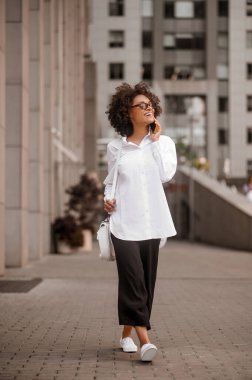 Genç bir kadın telefonda konuşuyor ve heyecanlı görünüyor.