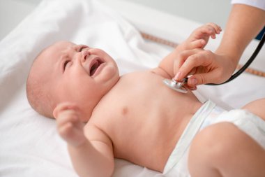 Göğüs bakımı sırasında kanepede uzanmış tatlı bir bebek.