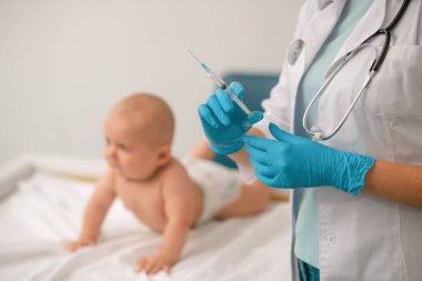 Azot eldivenli doktor iğne yapmaya hazırlanıyor.