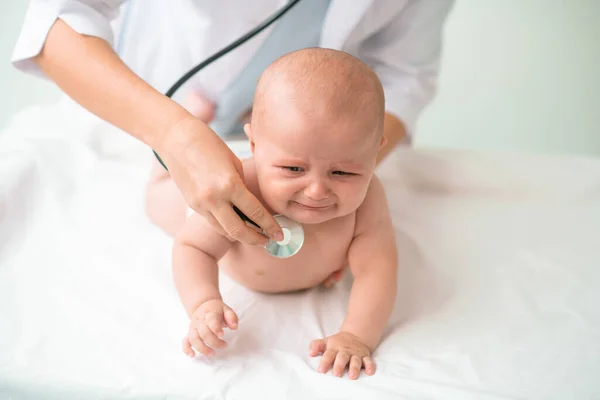 Θλιβερό μωρό που εξετάζεται από γιατρό με στηθοσκόπιο — Φωτογραφία Αρχείου