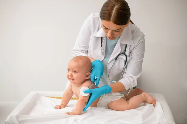 Profissional de saúde concentrou-se em vacinar um paciente recém-nascido — Fotografia de Stock