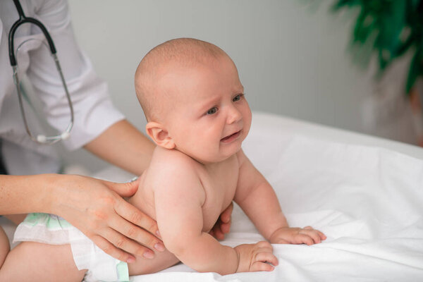 Frightened baby being examined by a healthcare professional