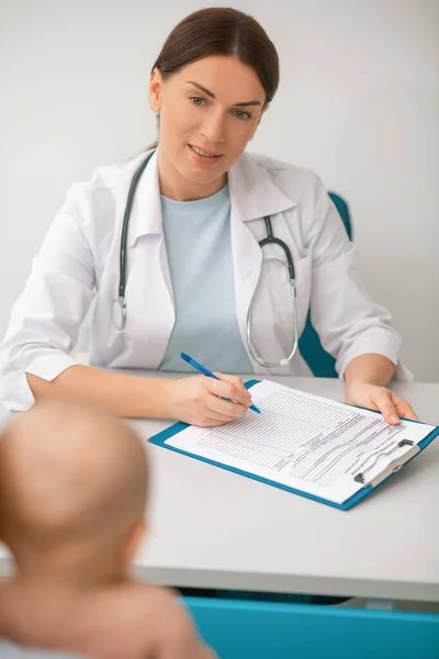 Junge Mutter besucht Kinderarzt mit ihrem kleinen Baby — Stockfoto