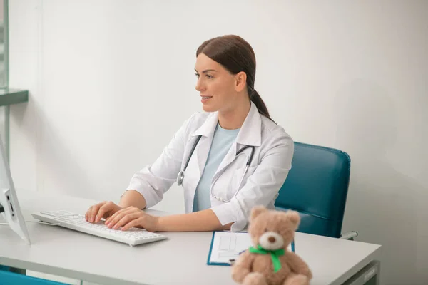 Una imagen de la doctora morena con una túnica blanca — Foto de Stock