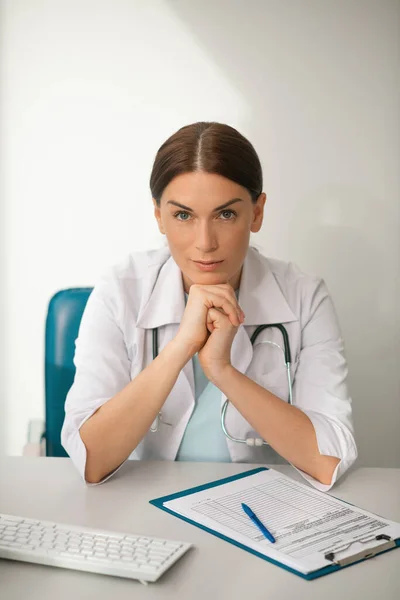 Uma boa aparência médica feminina em roupão branco olhando pensativo — Fotografia de Stock