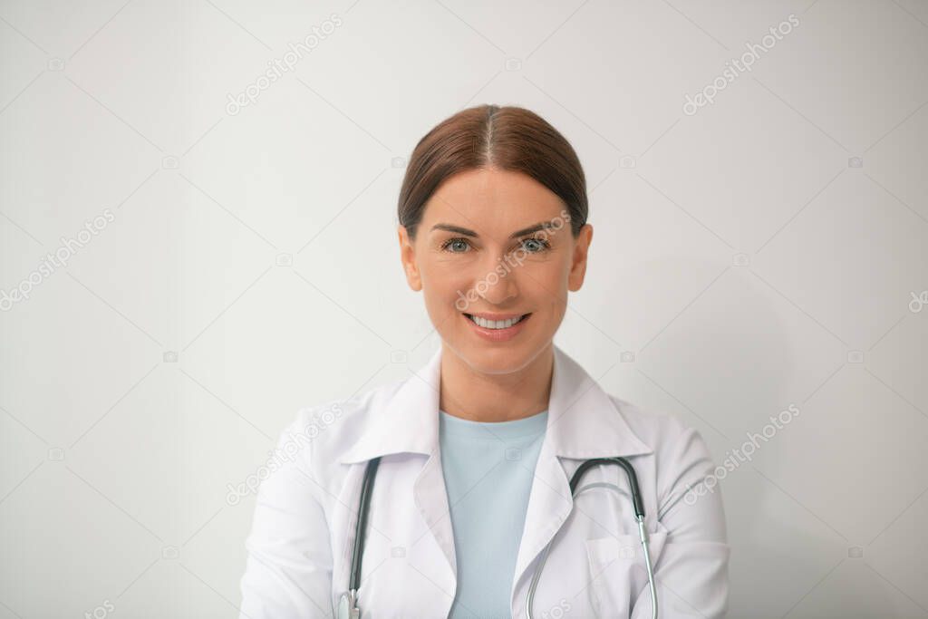 A picture of dark-haired female doctor in a white robe