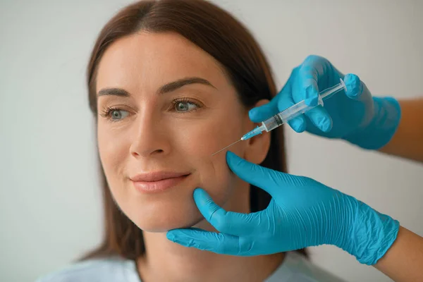 Cosmetologista injetando colágeno no rosto de seus clientes — Fotografia de Stock