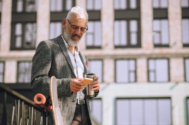 Elinde dökülmez bardakla olgun bir adam.