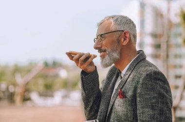 Elinde bir alet olan gri saçlı bir adam.