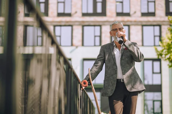 A man in an elegant jacket with a bottle in hand — Stock Photo, Image