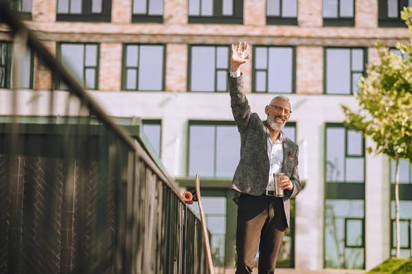 En mogen man står på gården nära offcie byggnaden — Stockfoto