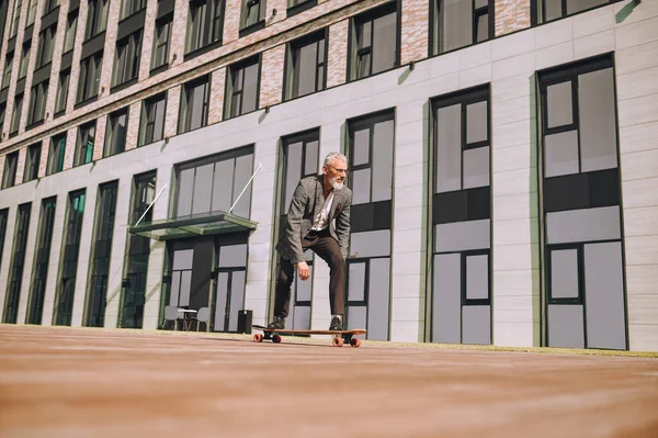 En man som åker skateboard framför kontorsbyggnaden — Stockfoto