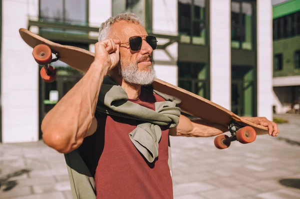 Sportig man med skateboard tittar i fjärran — Stockfoto