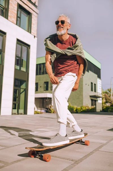 Energisk man stående med båda fötterna på skateboarden — Stockfoto