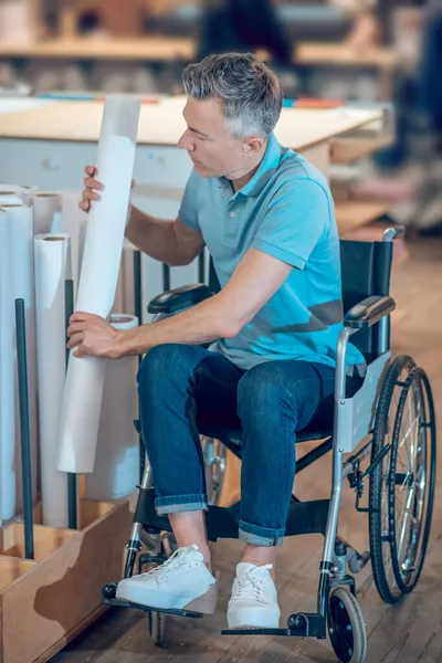 Άνδρας σε αναπηρική καρέκλα που παίρνει ρολό χαρτιού — Φωτογραφία Αρχείου