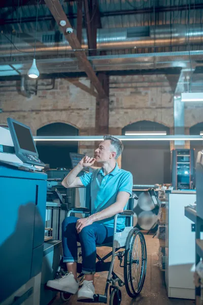 Άνδρας σε αναπηρική καρέκλα που κοιτάζει την οθόνη του εξοπλισμού γραφείου — Φωτογραφία Αρχείου