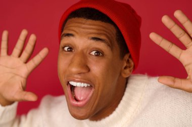 Beyaz kazaklı, sanat şapkalı Afro-Amerikan bir adam.