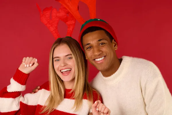 Mladý pár v rohatých klobouky na červeném pozadí — Stock fotografie