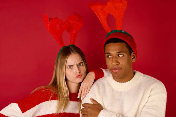 Dva mladí lidé v rohatých klobouky na červeném pozadí — Stock fotografie