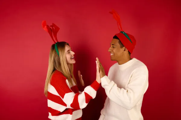 Mladý pár ve vánočním oblečení hledá těší — Stock fotografie