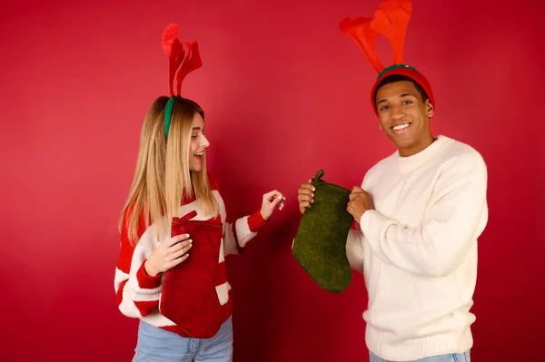 Mladí lidé drží vánoční punčochy — Stock fotografie