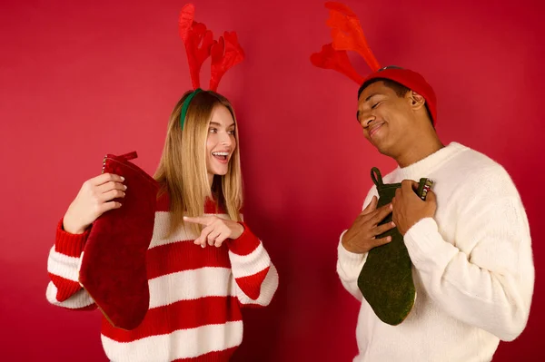 Mladí lidé drží vánoční punčochy — Stock fotografie