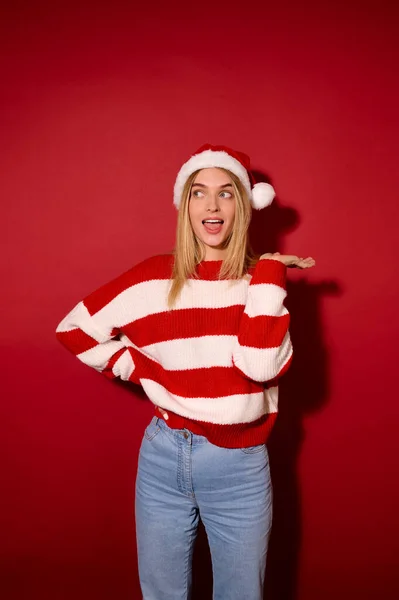Menina bonita em um chapéu de Papai Noel e uma camisola listrada — Fotografia de Stock