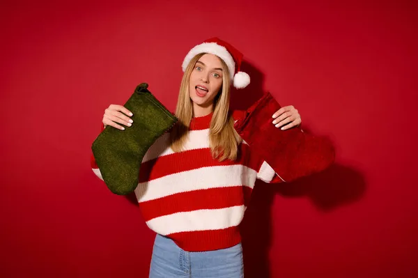 Dívka v Santa klobouku drží vánoční punčochy — Stock fotografie