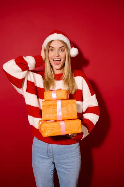 Dívka v pruhovaném svetru drží mnoho dárkových krabic — Stock fotografie