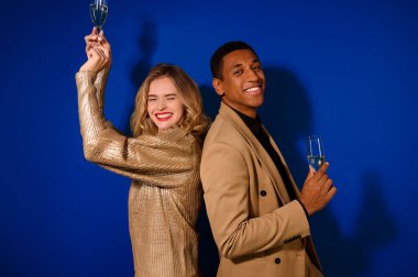 Adam ve kız sırtına dokunup neşeyle kameraya bakıyor.