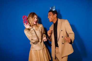 Tacın içindeki adam maskeli kıza bakıyor.