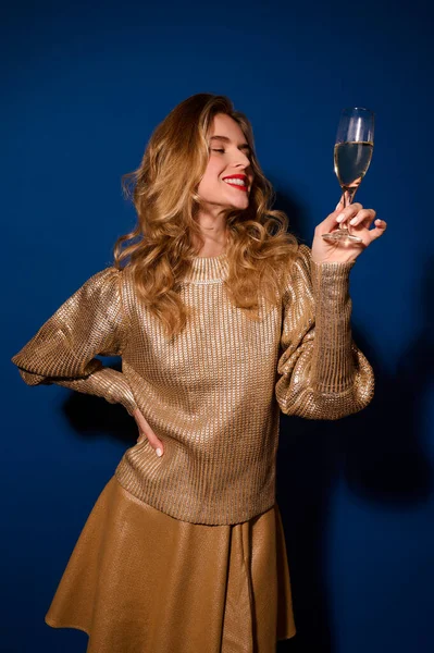 Menina solenemente olhando para o copo de champanhe na mão — Fotografia de Stock
