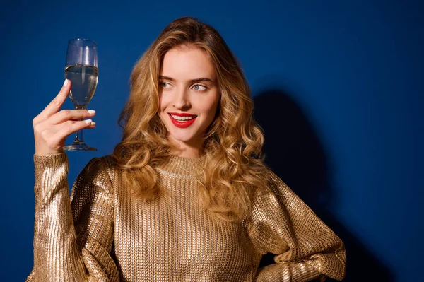 Menina olhando para o copo de champanhe segurando no nível do rosto — Fotografia de Stock