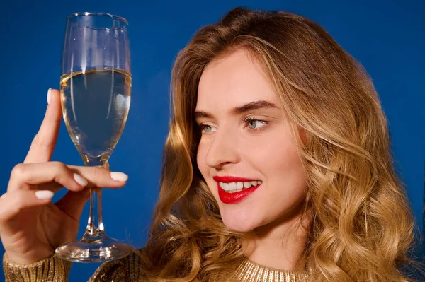 Rosto da menina olhando para o copo de champanhe — Fotografia de Stock
