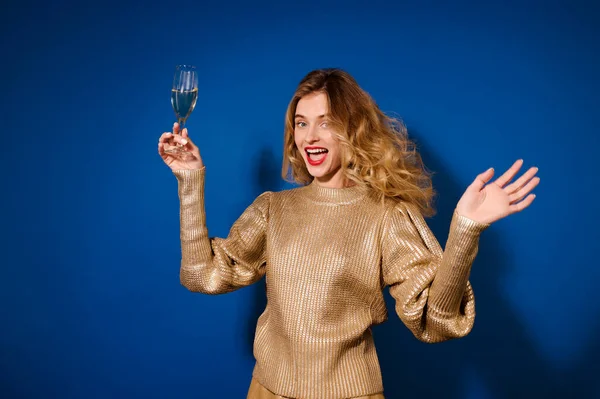 Menina emocional com copo de champanhe na mão levantada — Fotografia de Stock