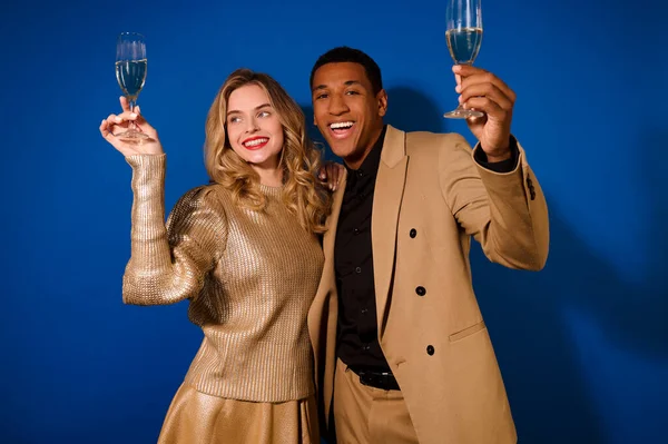 Парень и девушка обнялись, поднимая бокалы шампанского — стоковое фото