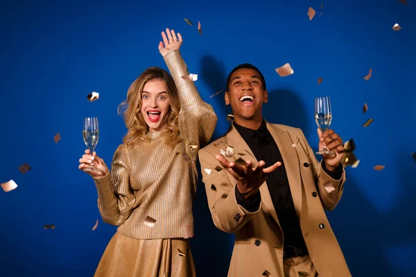 Guy e menina com champanhe regozijando voando confete — Fotografia de Stock