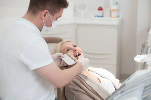 의사들에게 치과 치료를 받고 있는 금발의 환자 — 스톡 사진