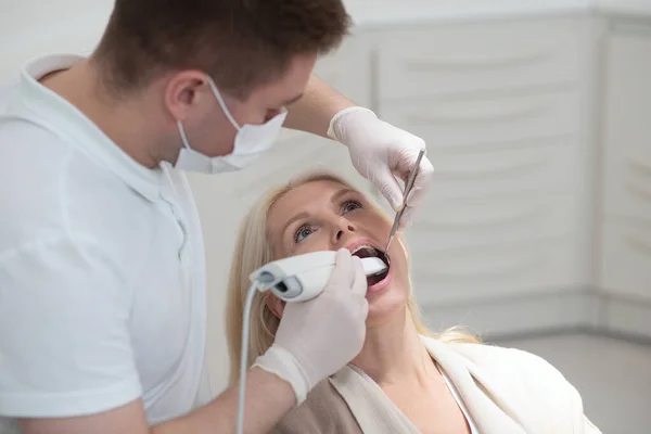 Dentista maschio facendo restauro dei denti ad una paziente femminile — Foto Stock