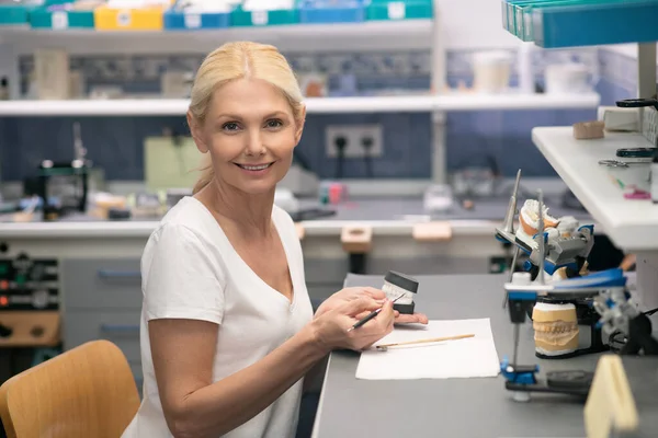 Eine Frau, die mit medizinischem Pflaster arbeitet und Zahnersatz herstellt — Stockfoto