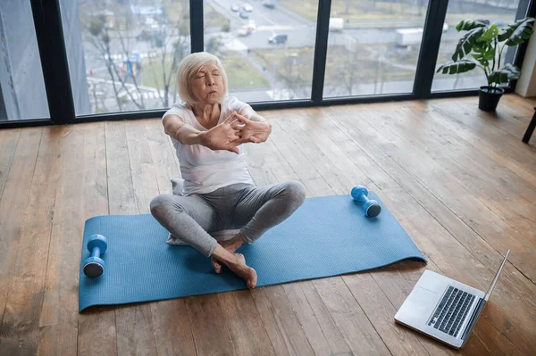 Grauhaarige Seniorin in Sportkleidung beim Stretching — Stockfoto