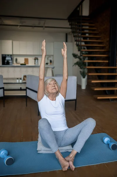 Gray-haired senior woman in sportswear doing stretching — 스톡 사진