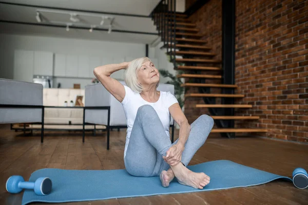 Frau in weißem T-Shirt und Leggins beim Stretching — Stockfoto