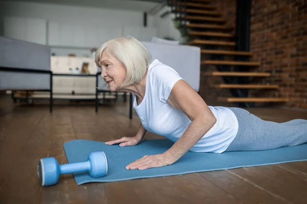 Senior active woman in a white tshirt doing plank — 스톡 사진