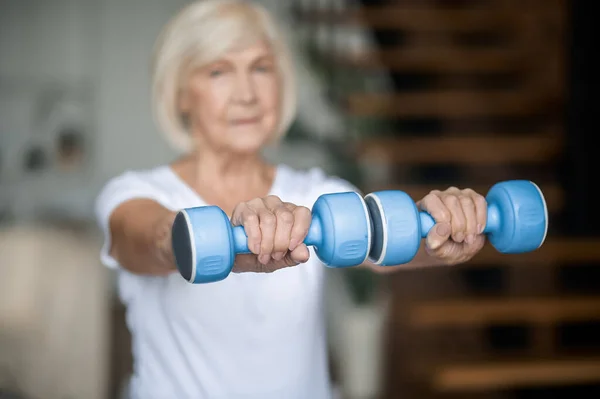 Active senior woman with dumbbells in hands doing her workout — Stockfoto