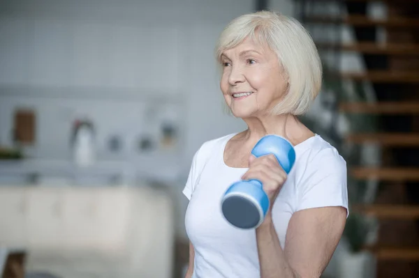 Short-haired senior woman exercising with dumbbells — Stockfoto