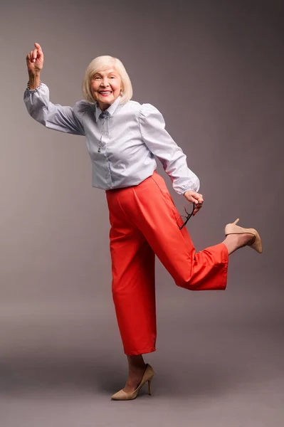 Mujer mayor feliz en pantalones rojos y camisa blanca — Foto de Stock