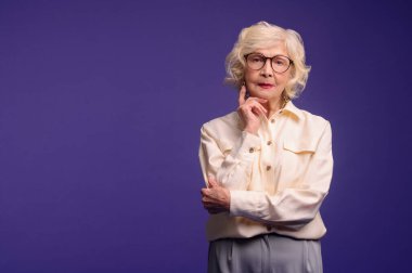 Slim and pretty blonde senior woman in stylish clothes