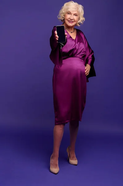 Hermosa mujer rubia senior en un vestido violeta de noche buscando disfrutado — Foto de Stock