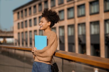 Gözkapakları açık, elinde egzersiz kitabı tutan bir kız.